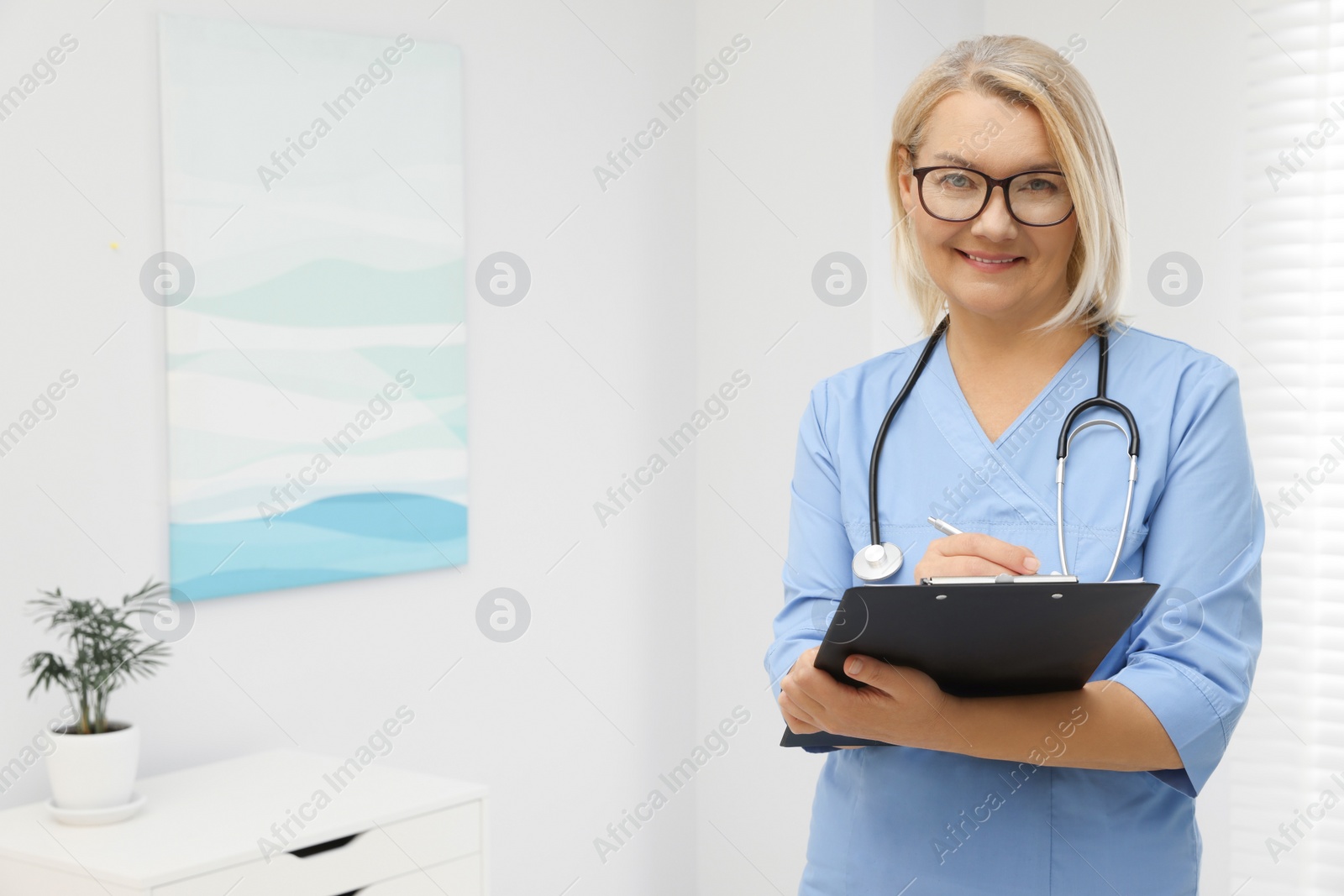 Photo of Doctor wearing uniform with clipboard in clinic