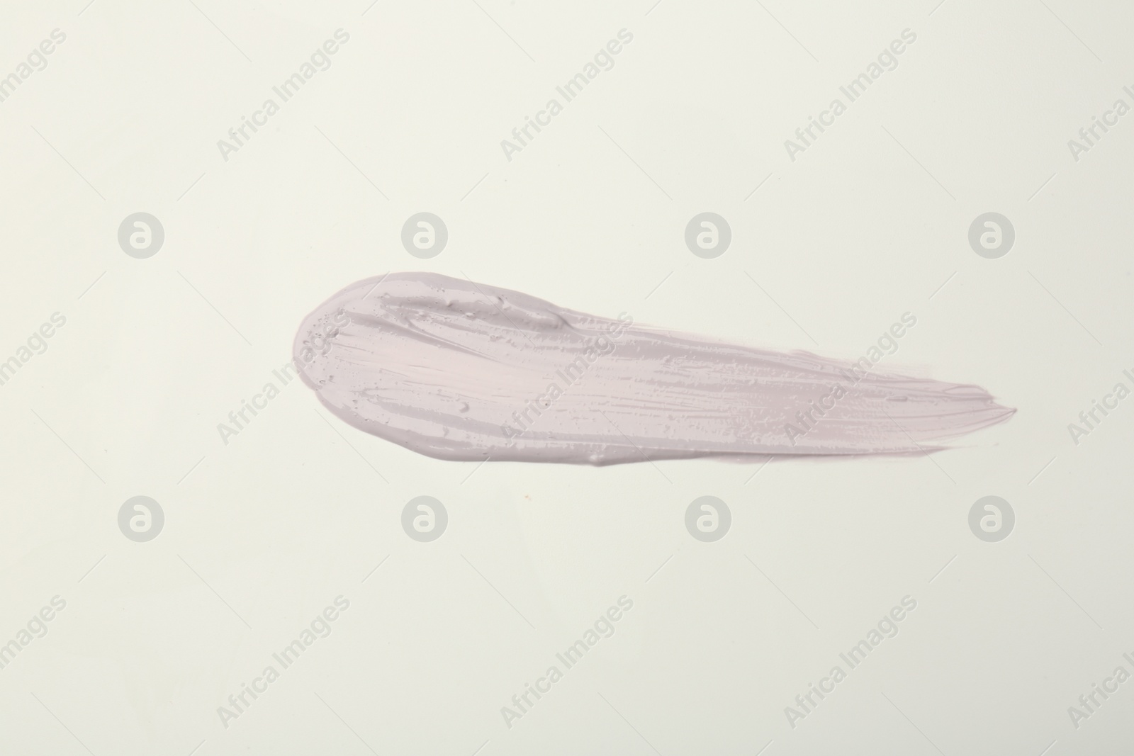 Photo of Stroke of purple color correcting concealer on white background, top view