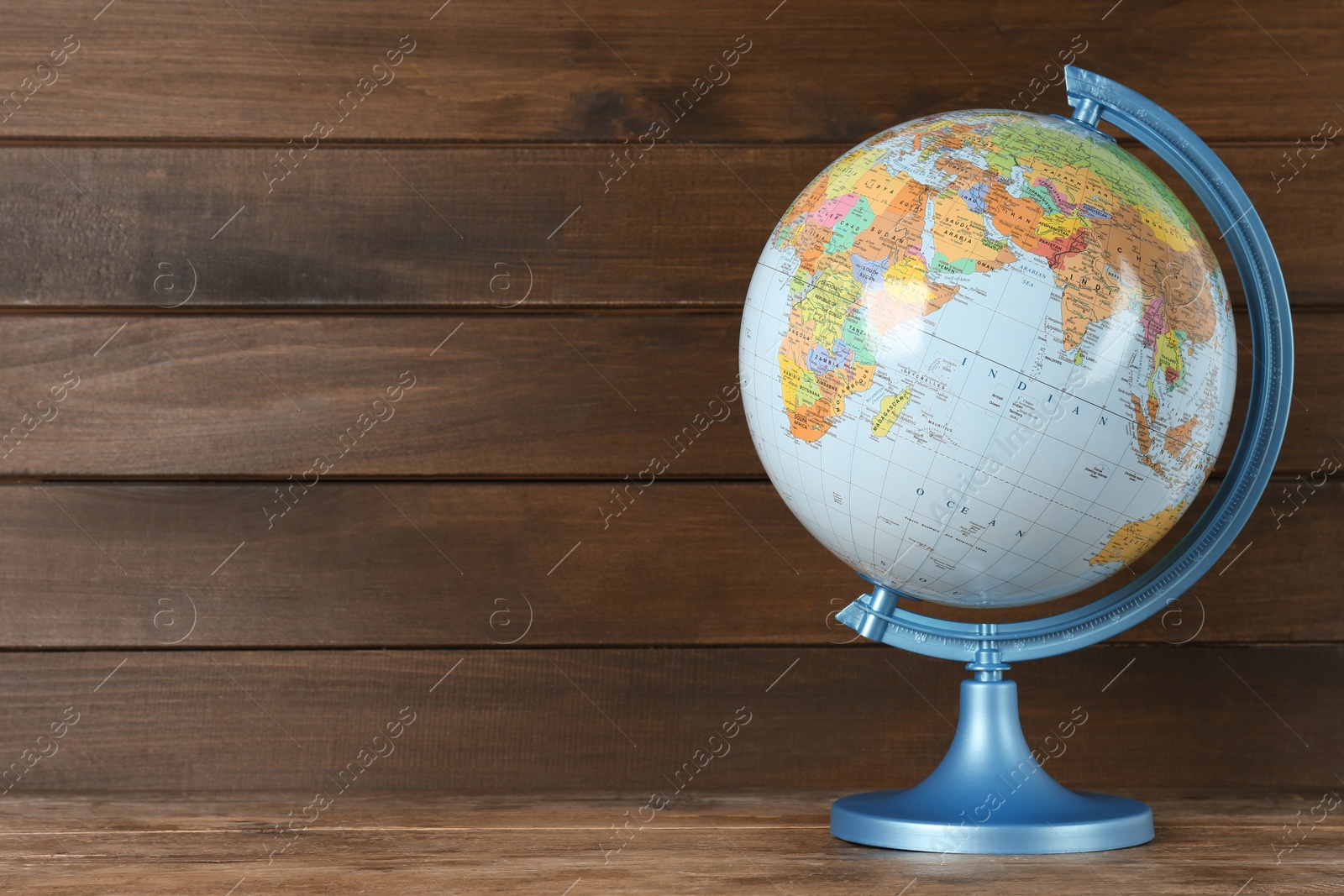 Photo of Plastic model globe of Earth on wooden table, space for text. Geography lesson