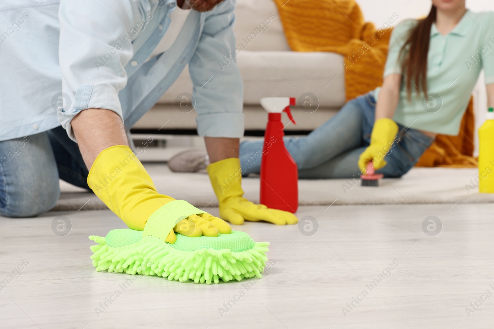 Photo of Spring cleaning. Couple tidying up living room together, closeup