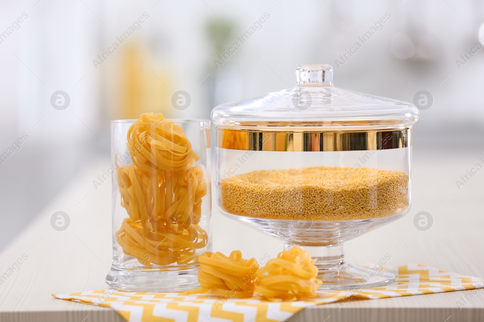 Photo of Raw pasta on wooden table in modern kitchen