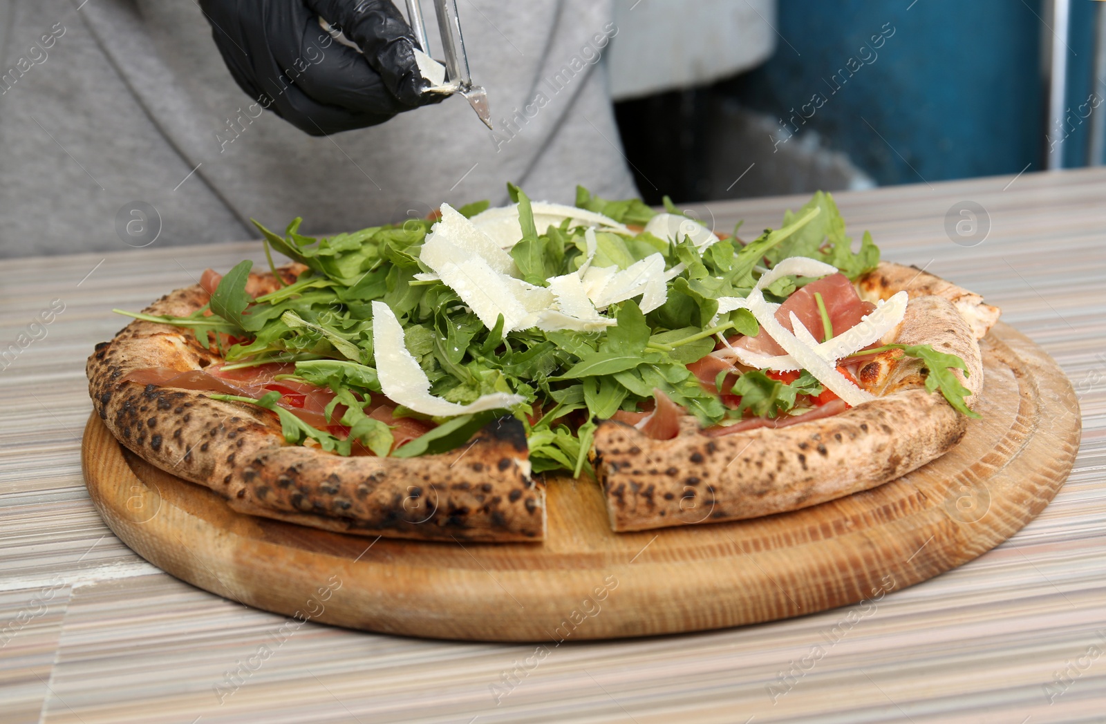 Photo of Professional chef preparing Italian oven baked pizza in restaurant, closeup