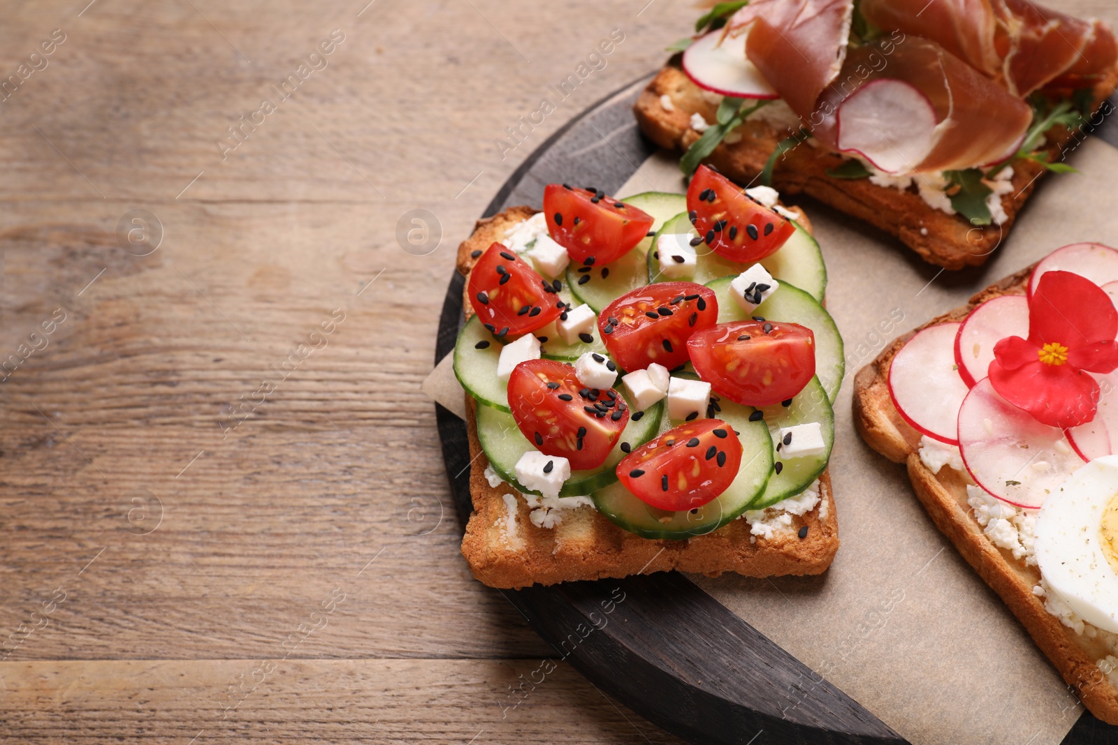 Photo of Different delicious sandwiches on wooden table, closeup. Space for text 