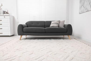 Photo of Living room with soft carpet and stylish sofa. Modern interior