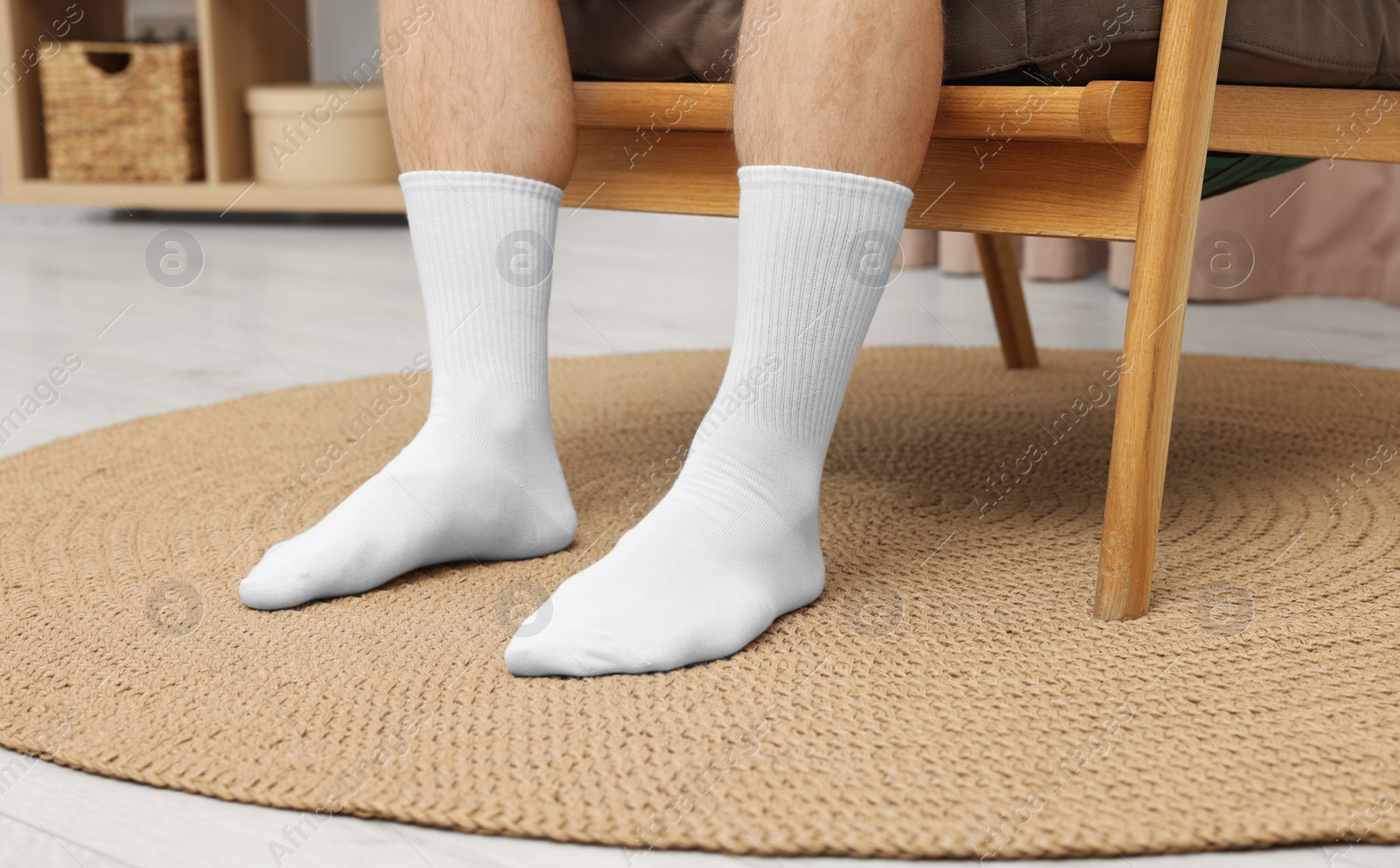 Photo of Man in stylish white socks in armchair indoors, closeup