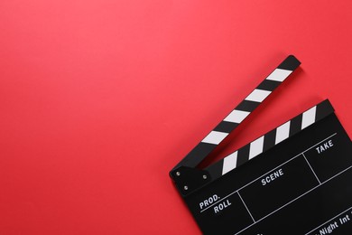 Photo of Clapperboard on red background, top view. Space for text