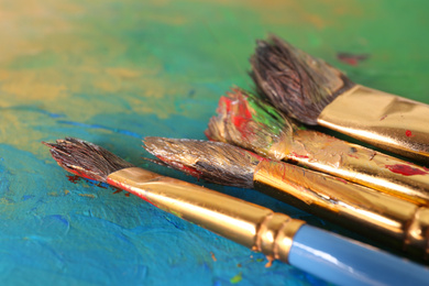 Photo of Abstract colorful artwork and brushes, closeup view