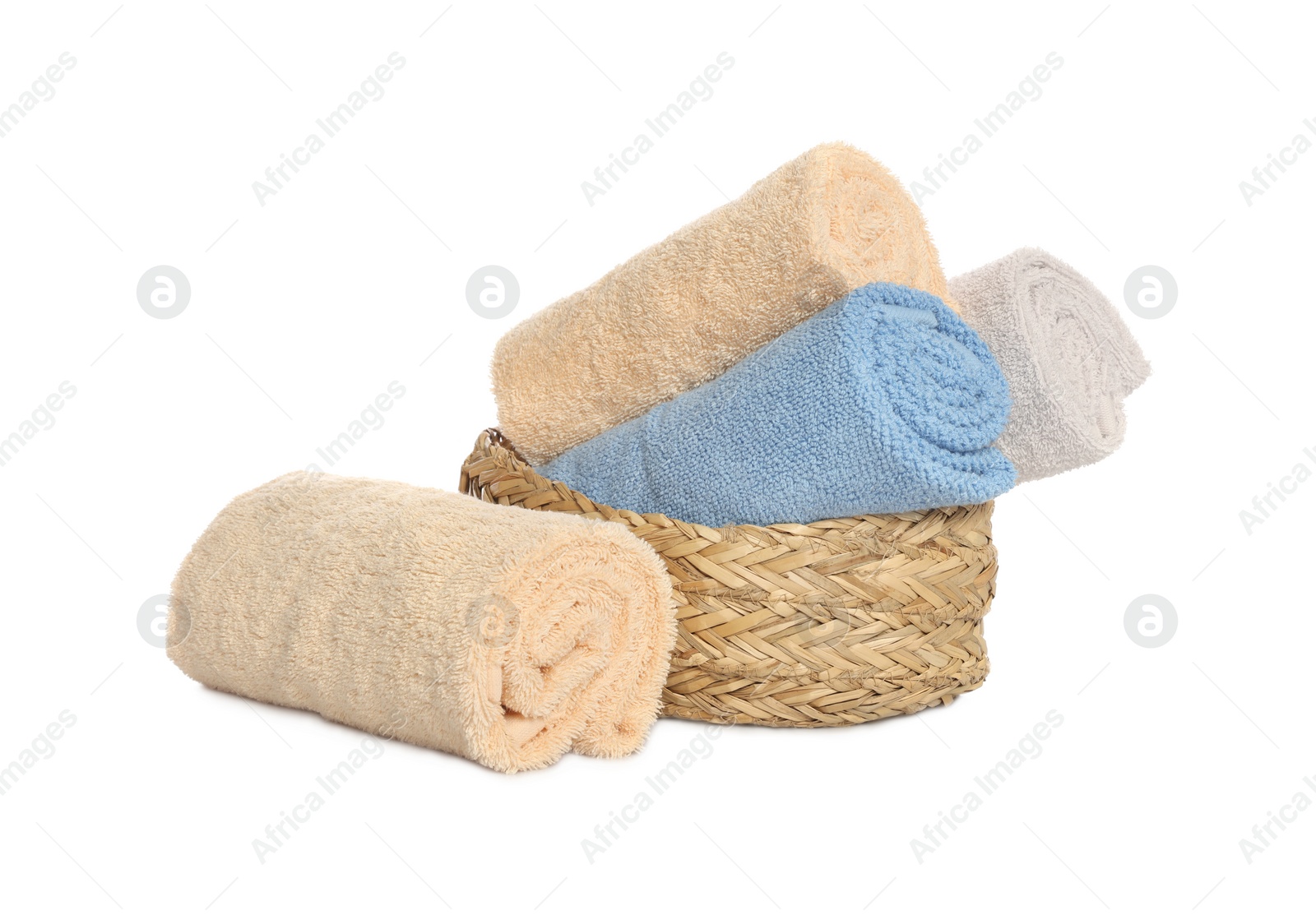 Photo of Wicker basket and rolled bath towels on white background