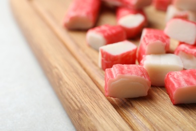 Photo of Cut crab sticks on wooden board, closeup