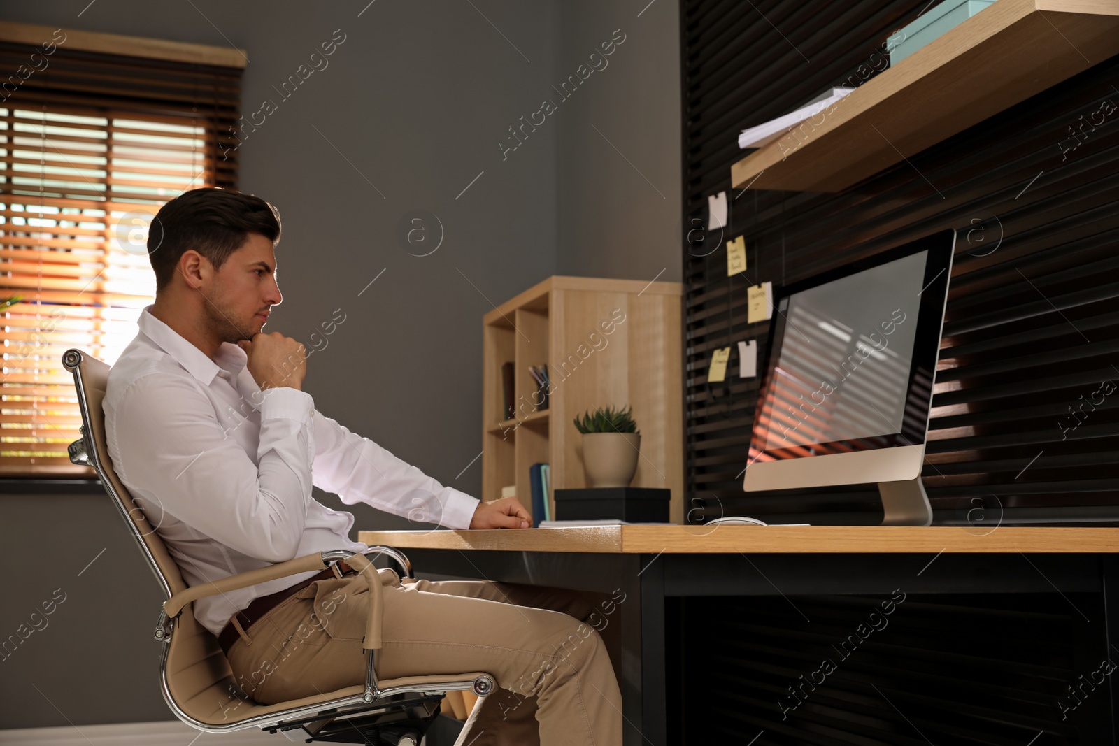 Photo of Man sitting at comfortable workplace with modern computer