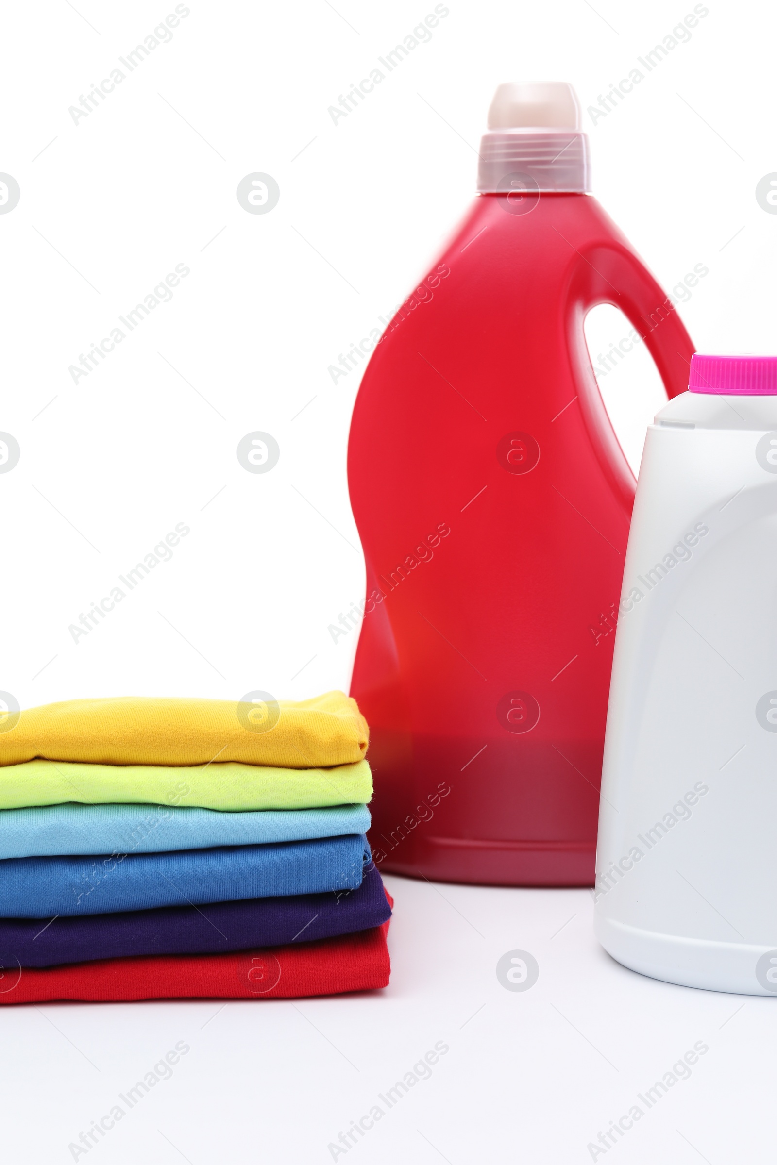 Photo of Stack of baby clothes and laundry detergents isolated on white