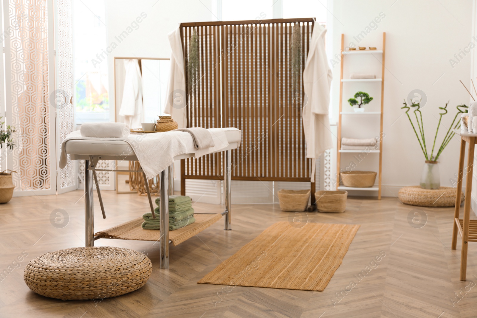 Photo of Stylish room interior with massage table in spa salon