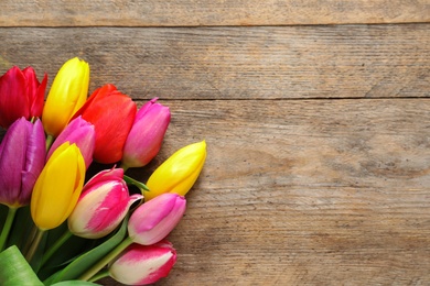 Photo of Beautiful tulips and space for text on wooden background, top view. Spring flowers