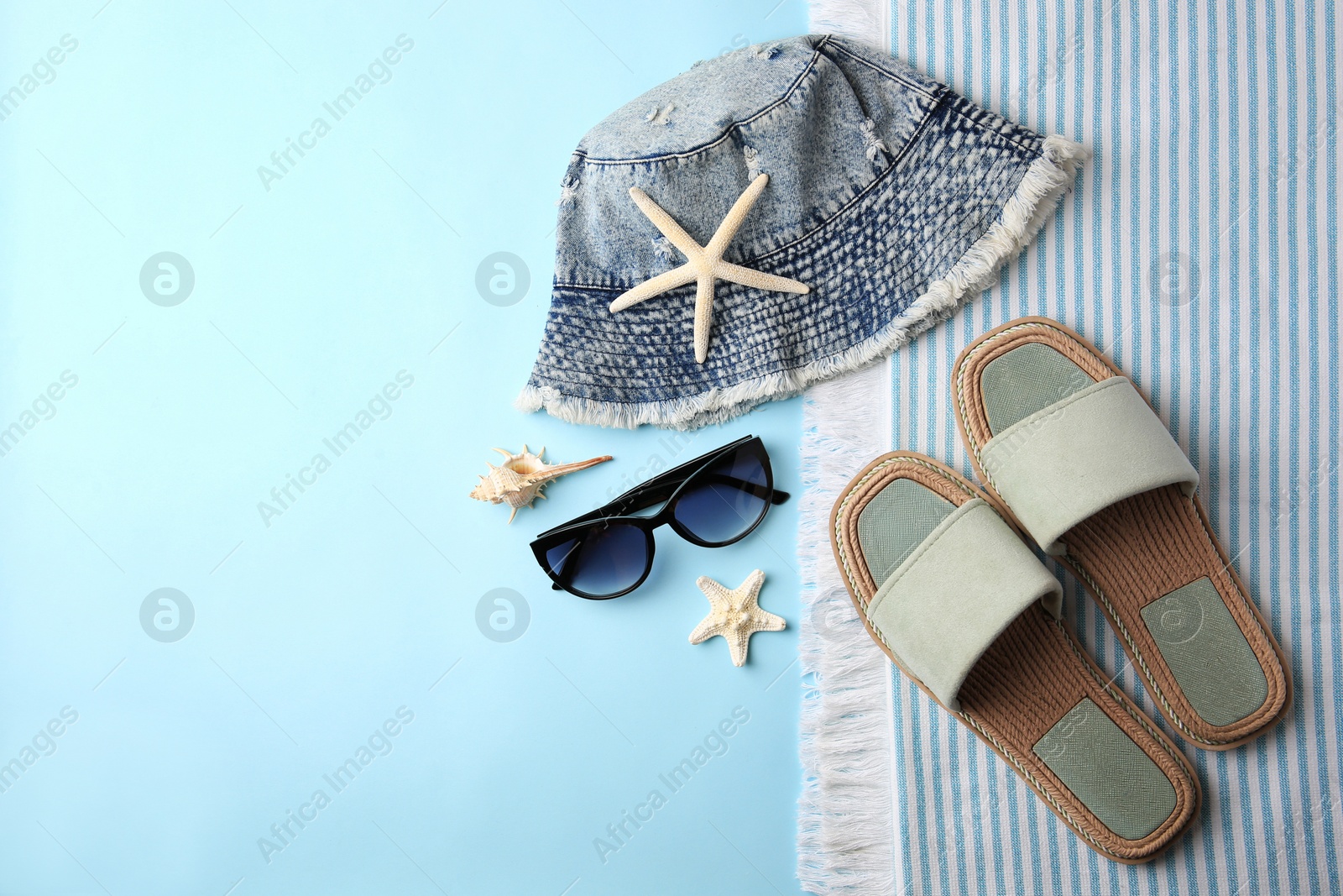 Photo of Flat lay composition with beach accessories on light blue background, space for text