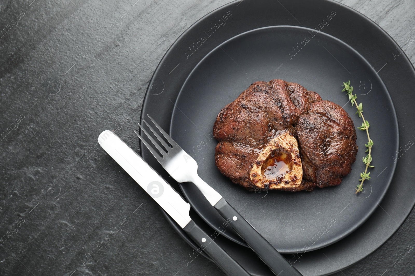 Photo of Tasty grilled beef meat served on black table, top view