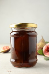 Jar of tasty sweet fig jam on light table