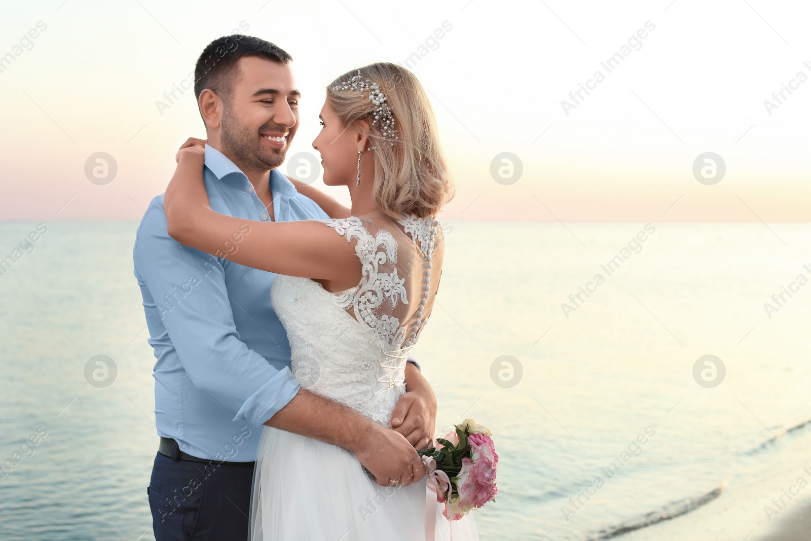 Photo of Wedding couple hugging on beach. Space for text