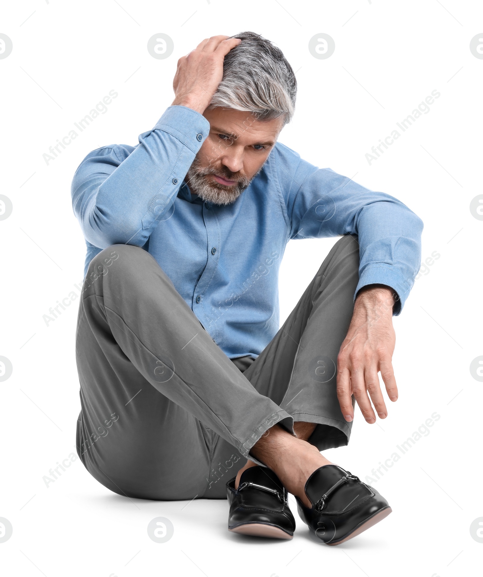 Photo of Mature businessman in stylish clothes sitting on white background