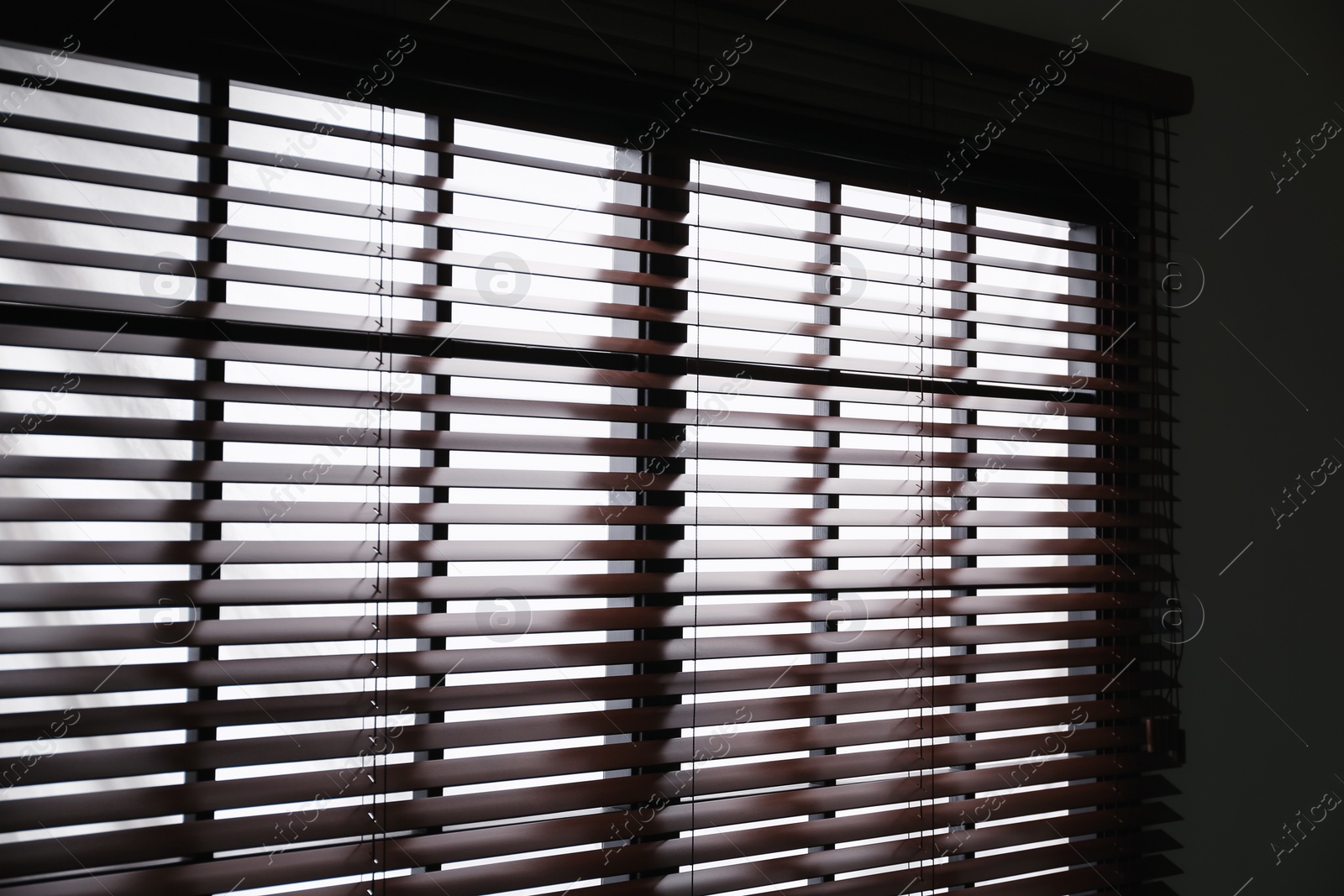 Photo of Modern window with stylish wooden blinds indoors