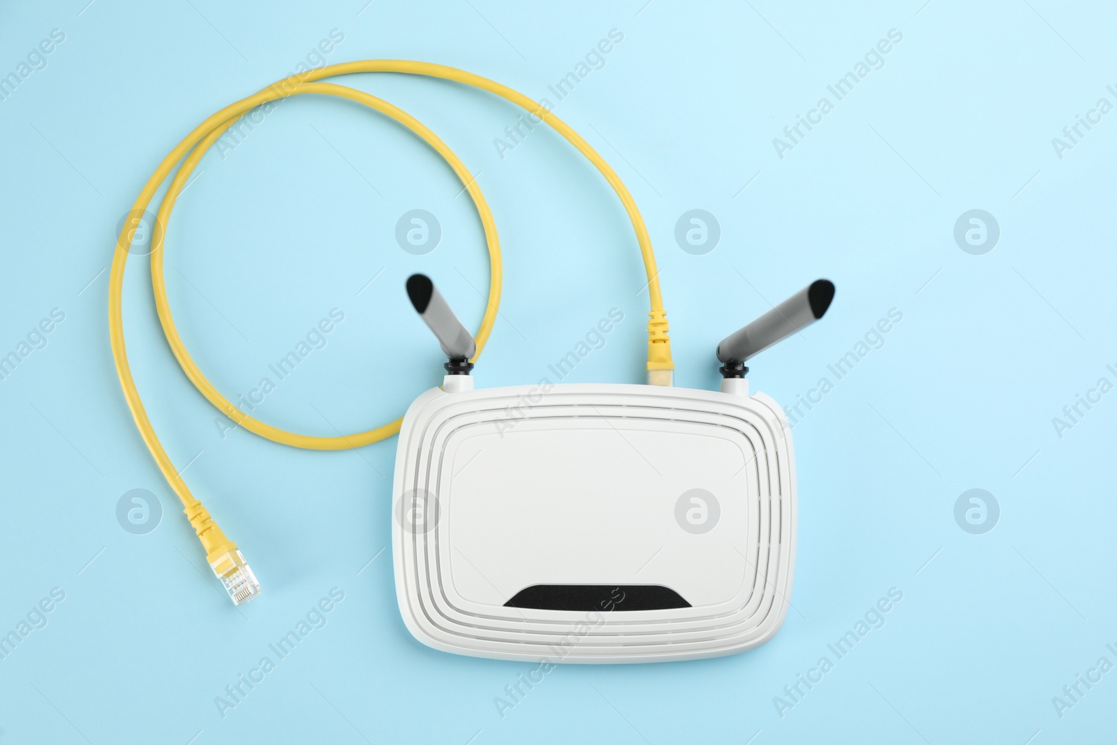 Photo of Modern Wi-Fi router on light blue background, top view