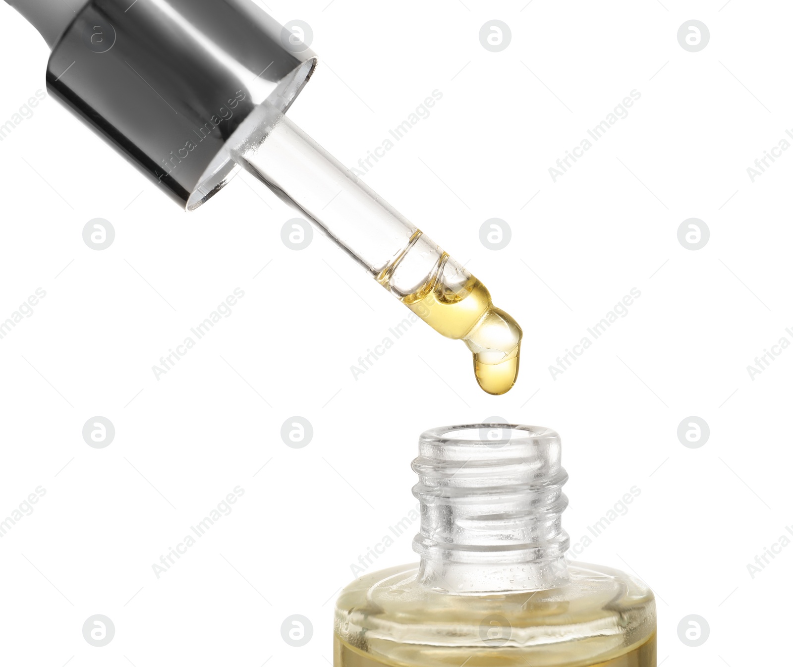 Photo of Dripping essential oil from pipette into glass bottle on white background