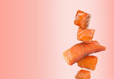 Image of Cut fresh salmon falling on pink gradient background, space for text