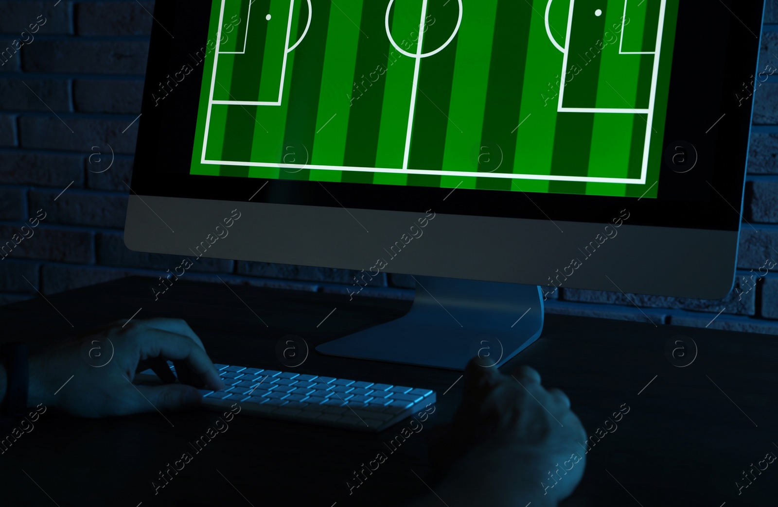 Photo of Man playing video game at table in dark room, closeup