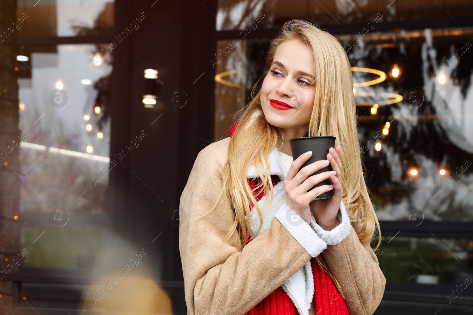 Photo of Young woman with hot drink at winter fair. Christmas celebration