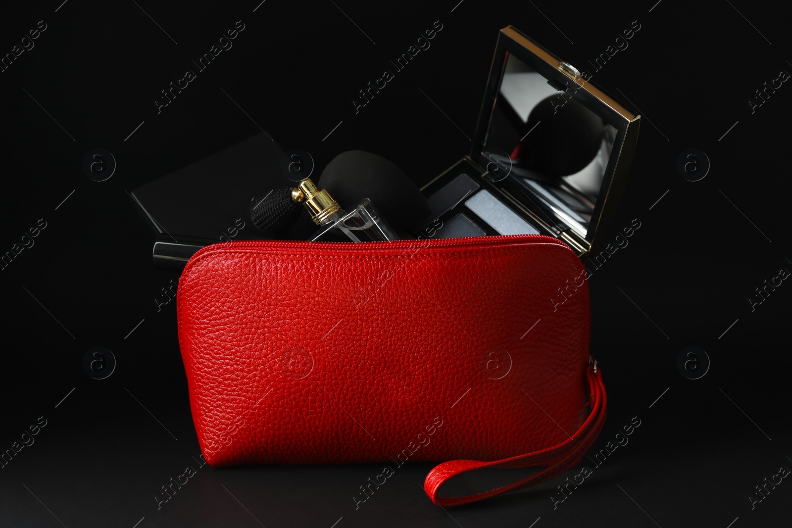 Photo of Cosmetic bag with makeup products and beauty accessories on black background