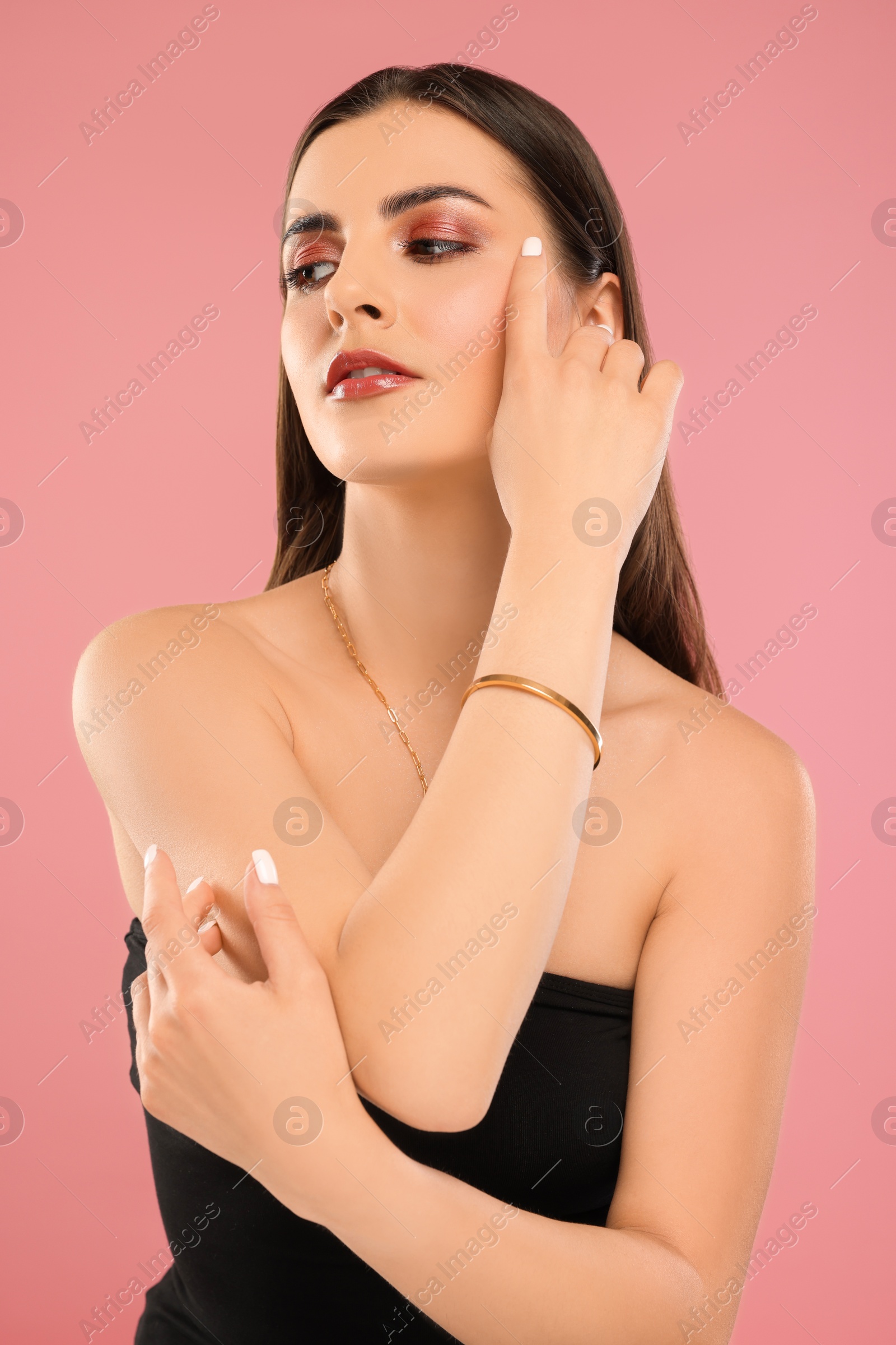 Photo of Beautiful woman with elegant jewelry on pink background