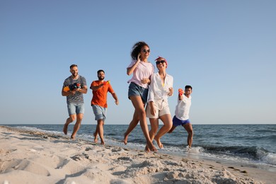 Group of friends with water guns having fun on beach