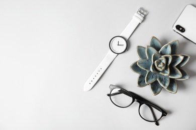 Flat lay composition with stylish wrist watch and space for text on gray table. Fashion accessory