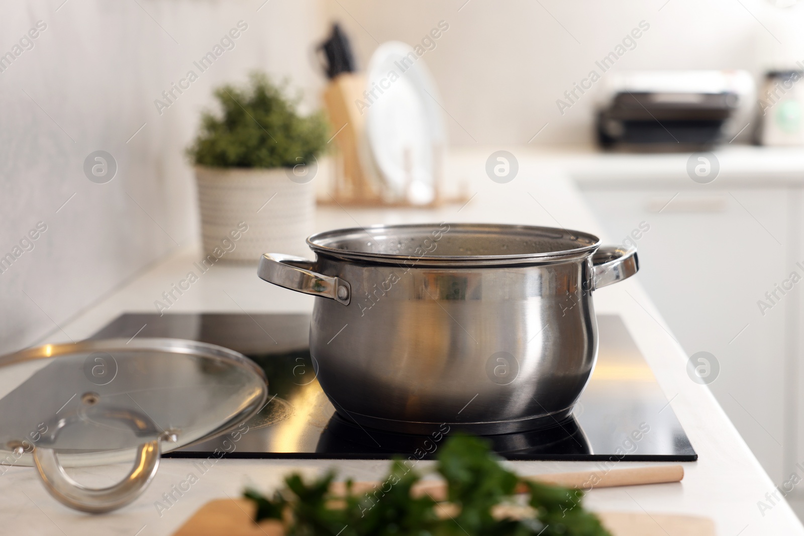 Photo of Pot with tasty soup on cooktop in kitchen