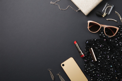 Flat lay composition with cosmetics and stylish accessories on black background. Space for text