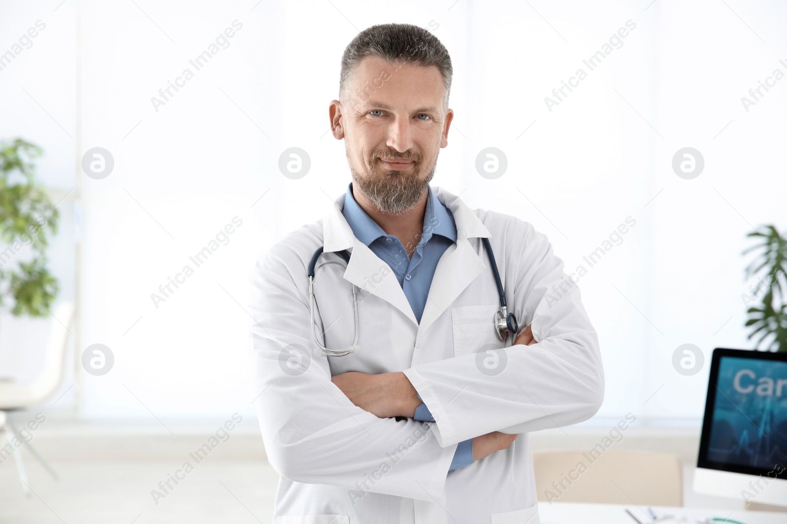 Photo of Portrait of male doctor in coat at workplace in clinic. Cardiology center