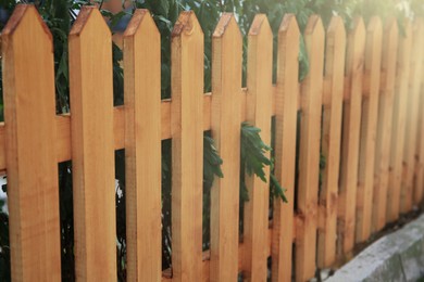 Photo of Wooden fence outdoors on sunny day, closeup