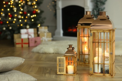 Christmas lanterns with burning candles in decorated living room. Space for text