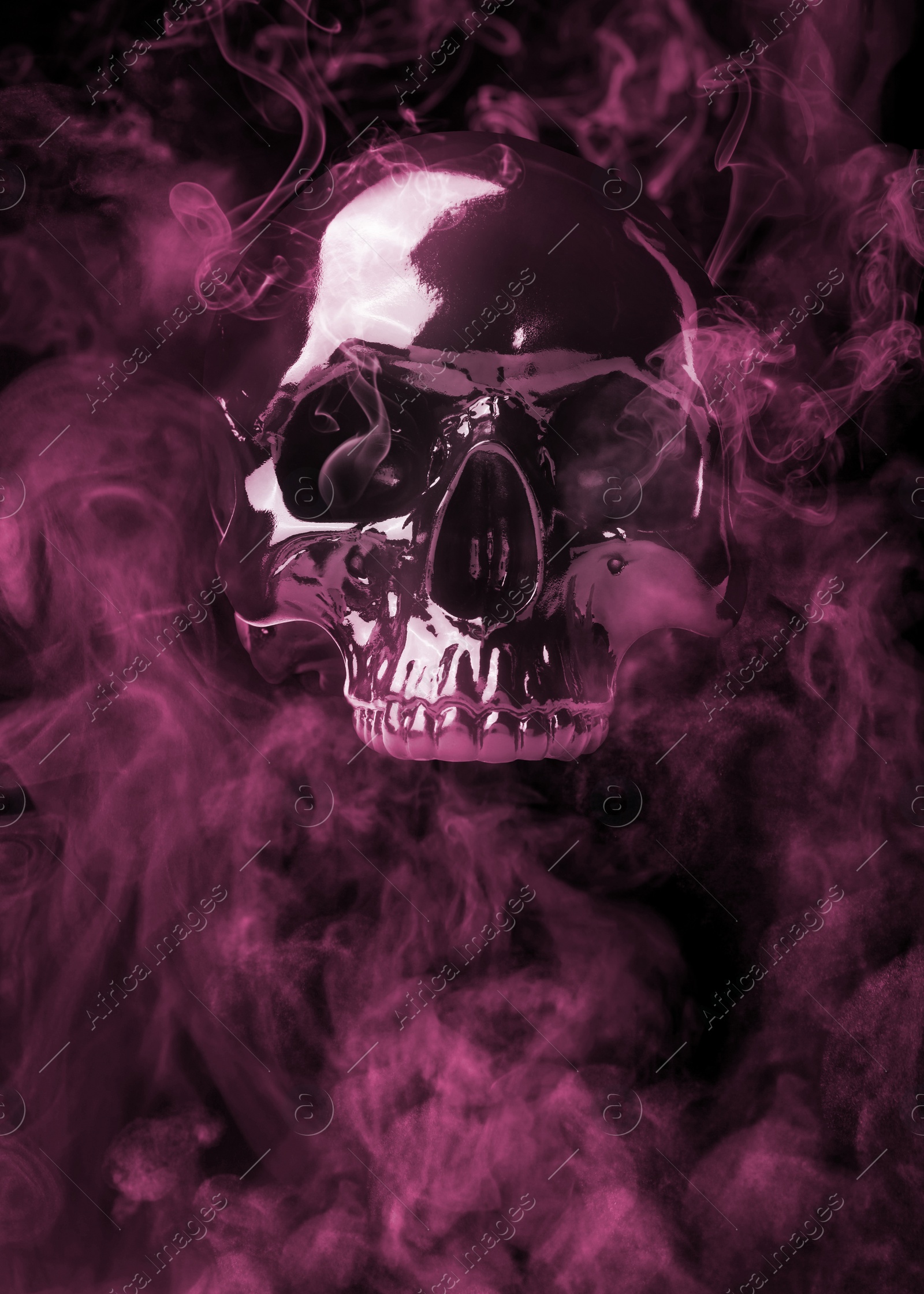 Image of Scary skull emerging from smoke in darkness