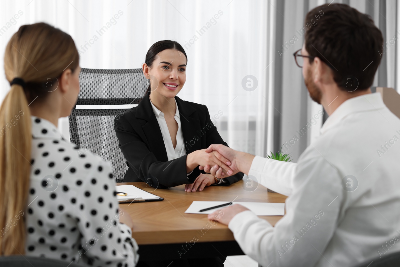 Photo of Lawyer shaking hands with clients in office