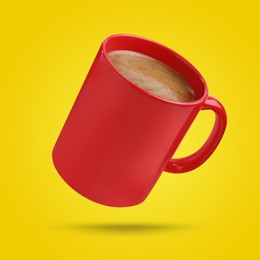 Red cup of coffee drink levitating on yellow background