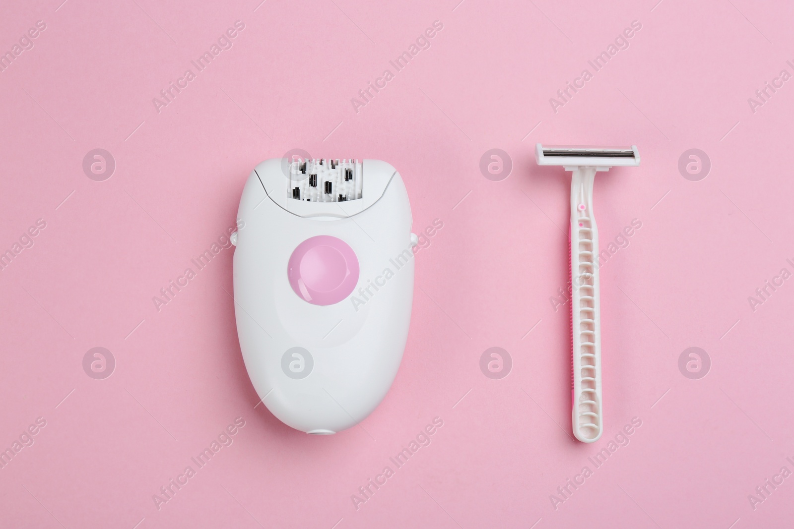 Photo of Modern epilator and razor on pink background, flat lay