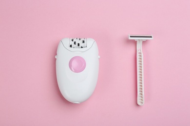 Photo of Modern epilator and razor on pink background, flat lay