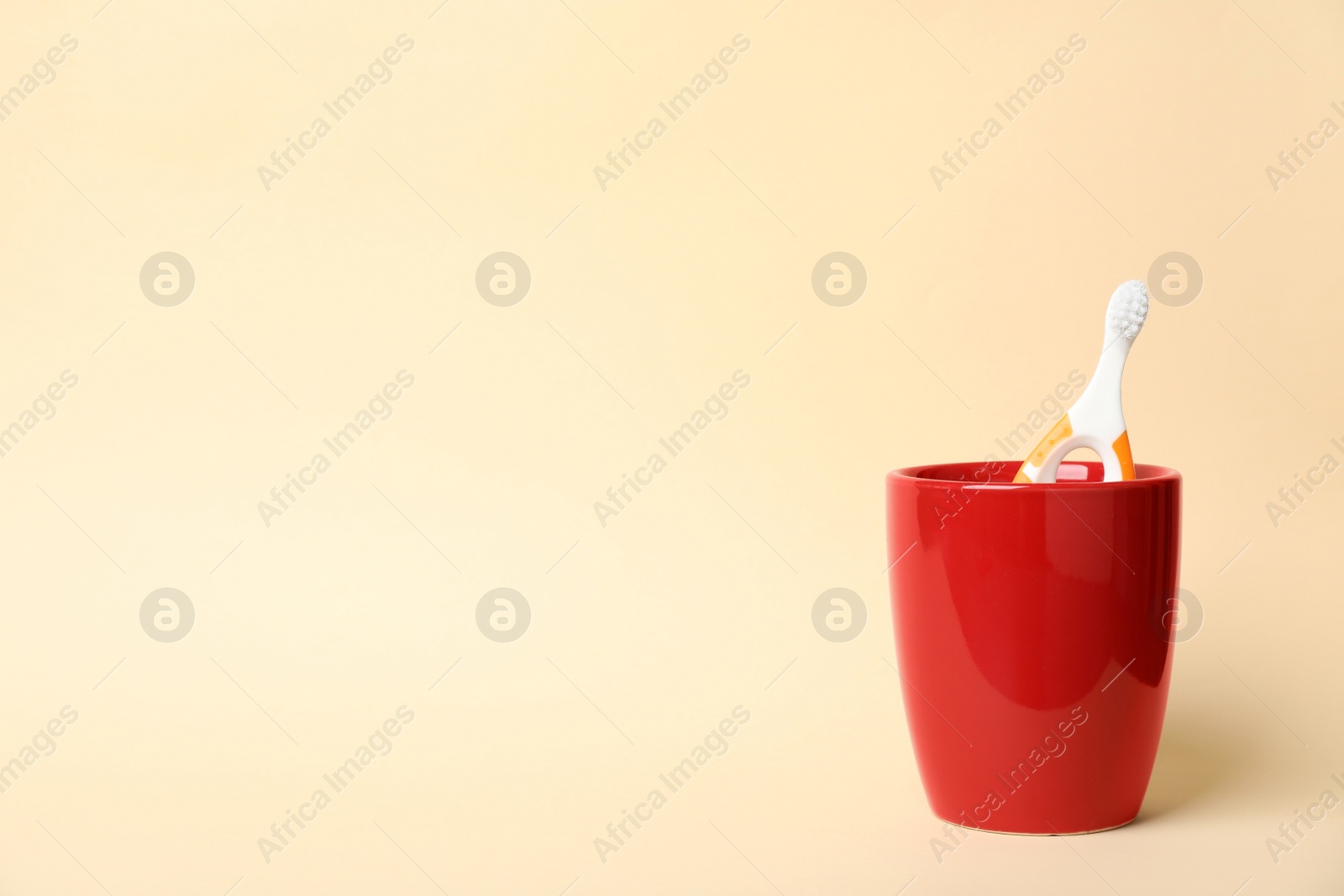 Photo of Baby toothbrush in holder and space for text on color background