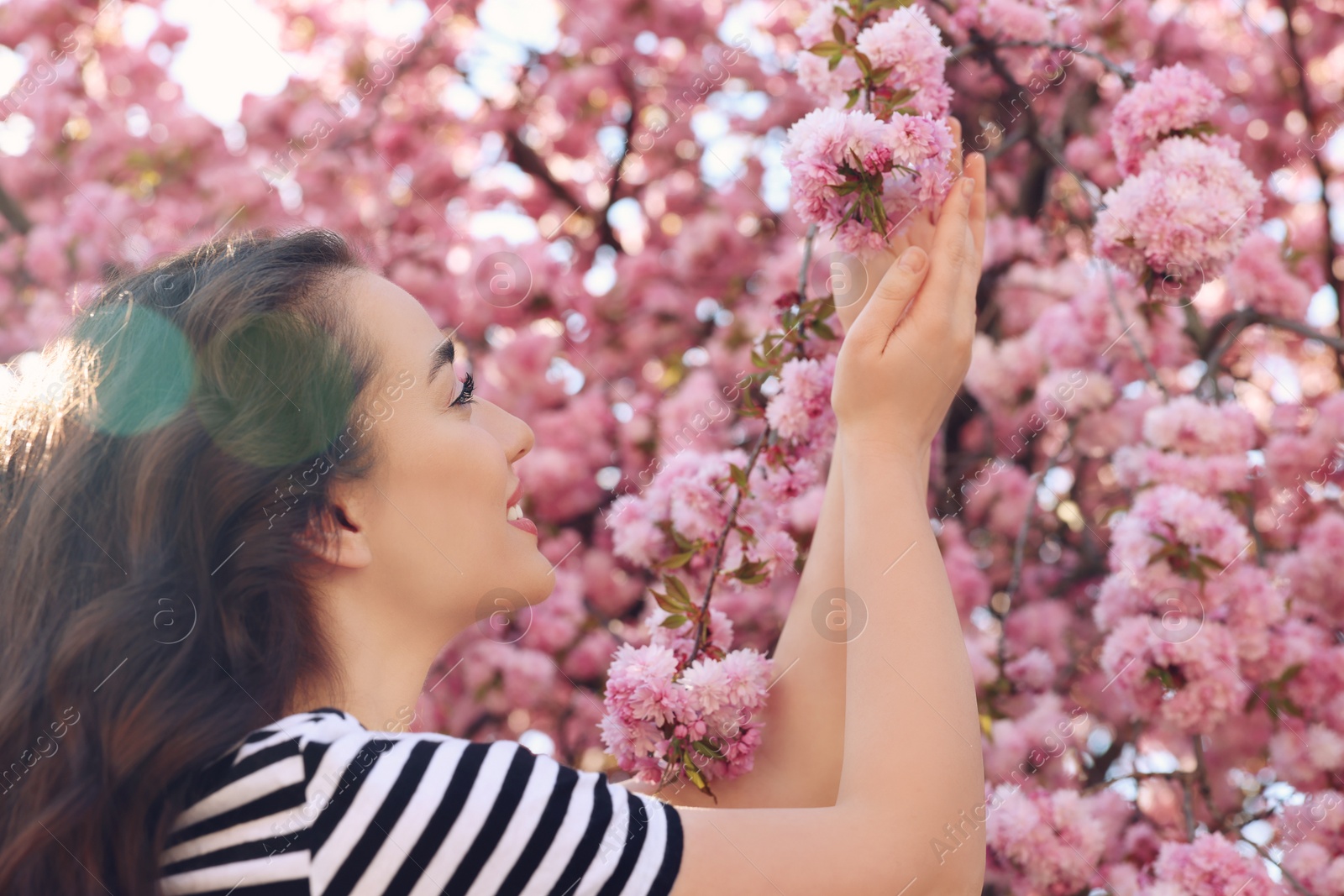 Photo of Beautiful woman near blossoming sakura tree on spring day