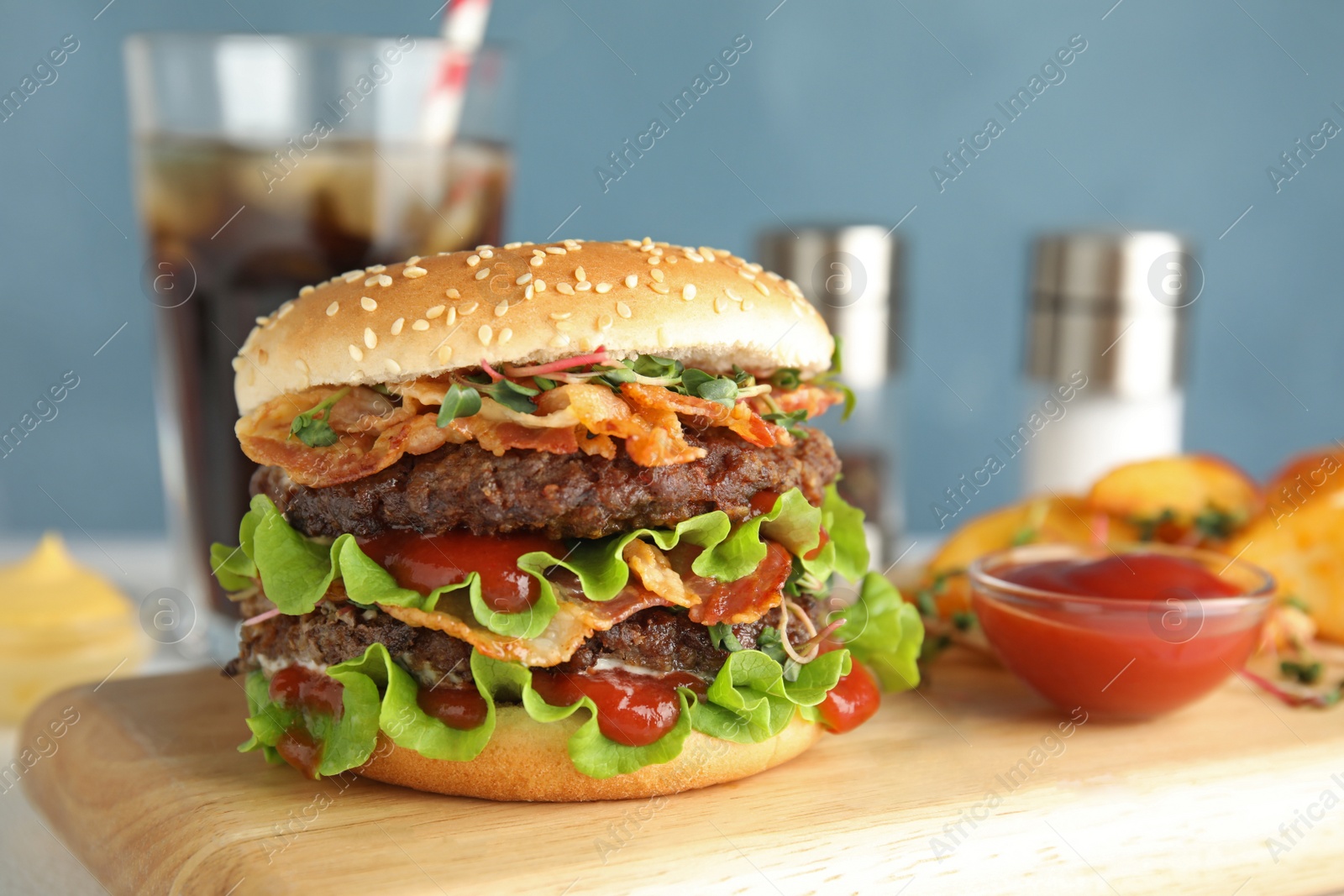 Photo of Tasty burger with bacon served on board, space for text