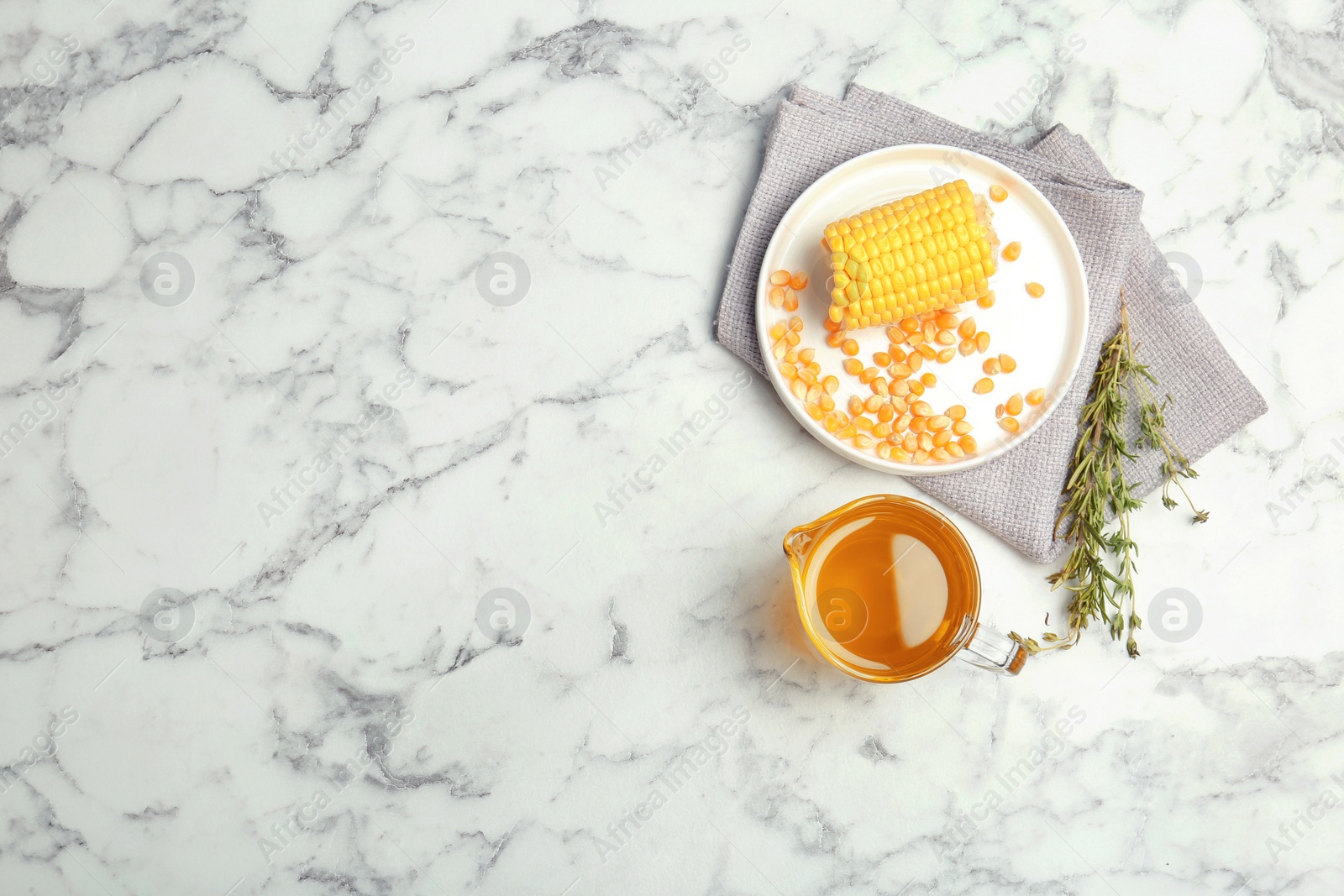 Photo of Flat lay composition with corn and jug of oil on marble background