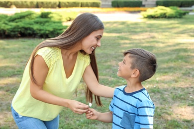 Photo of Mother with her cute child in green park on sunny day. Happy family