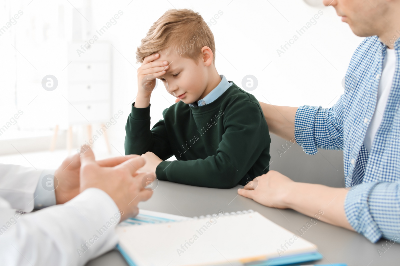 Photo of Young man with his son having appointment at child psychologist office