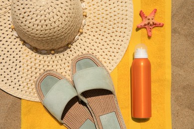 Sunscreen, starfish and beach accessories on sand, top view. Sun protection care