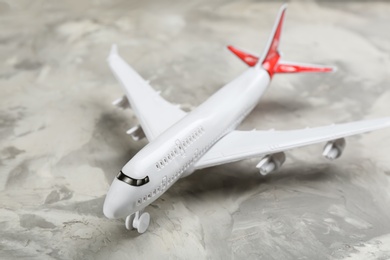 Photo of Toy airplane on grey background, closeup. Travel concept